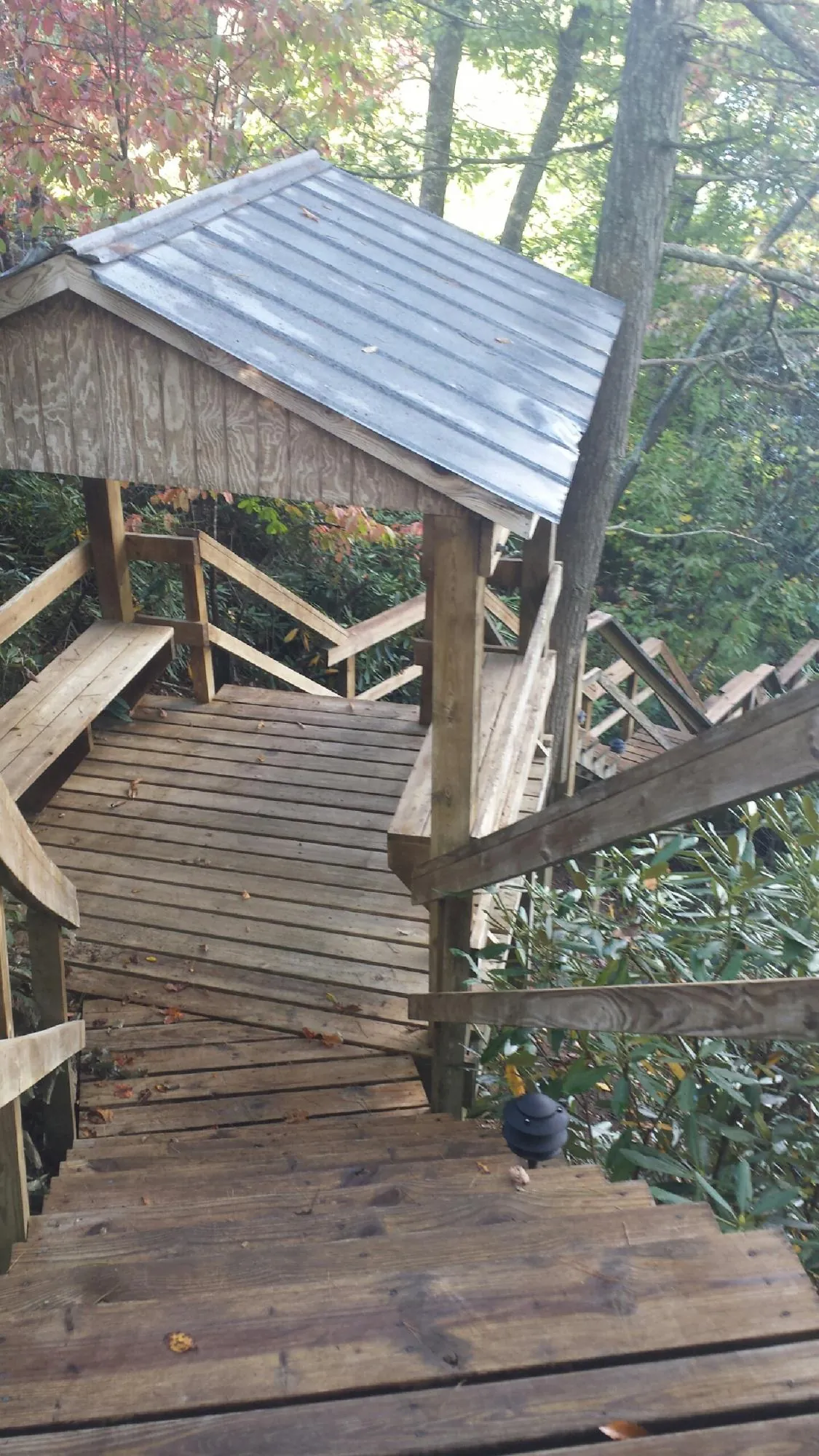 Metal roofed shelter over wooden steps on a wooded walkway — Skylight Repair & Installation work by our crew in West Point